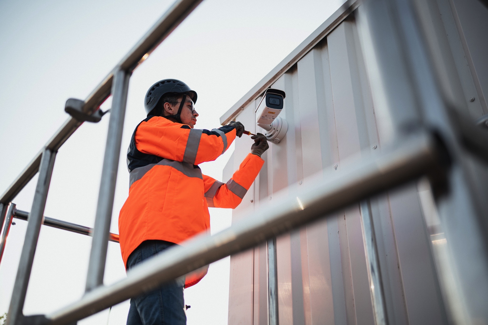 Photo d'un technicien intervenant sur une caméra de vidéosurveillance