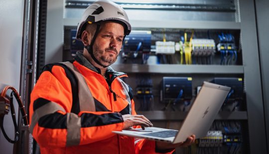 Photo d'un technicien devant une armoire électrique d'automates