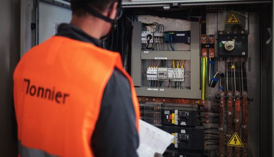 Photo d'un technicien de maintenance devant une armoire électrique