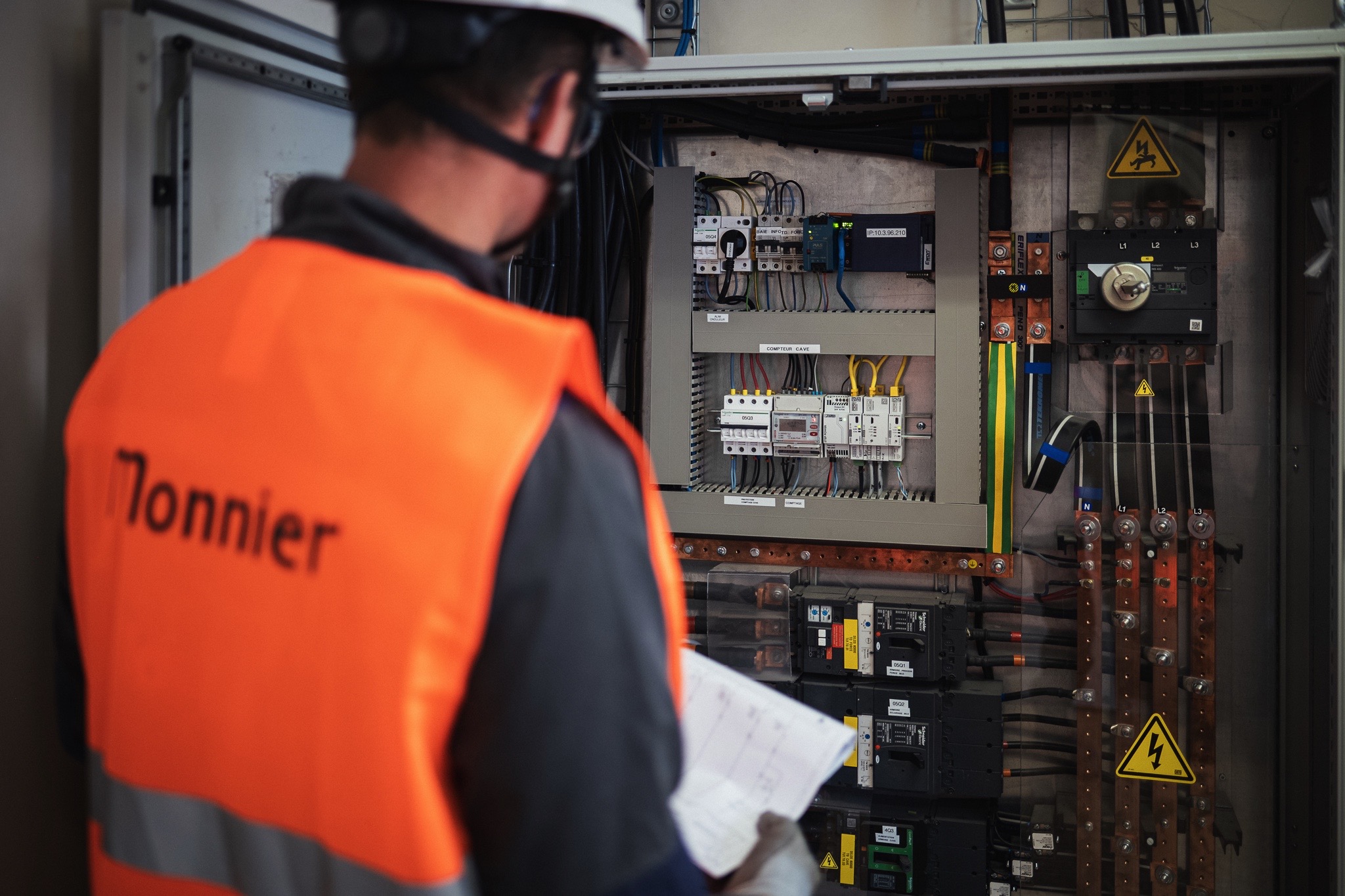 Photo d'un technicien de maintenance devant une armoire électrique