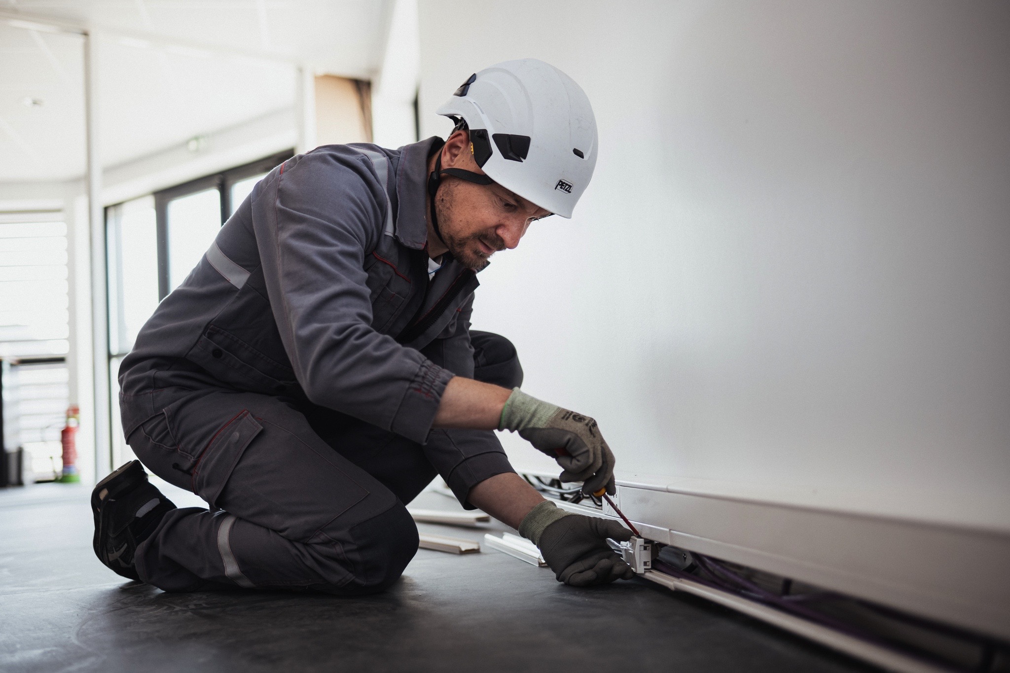 Photo d'un technicien travaillant dans une gaine électrique